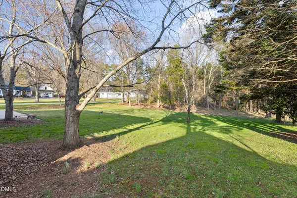 a view of a house with a yard covered with trees