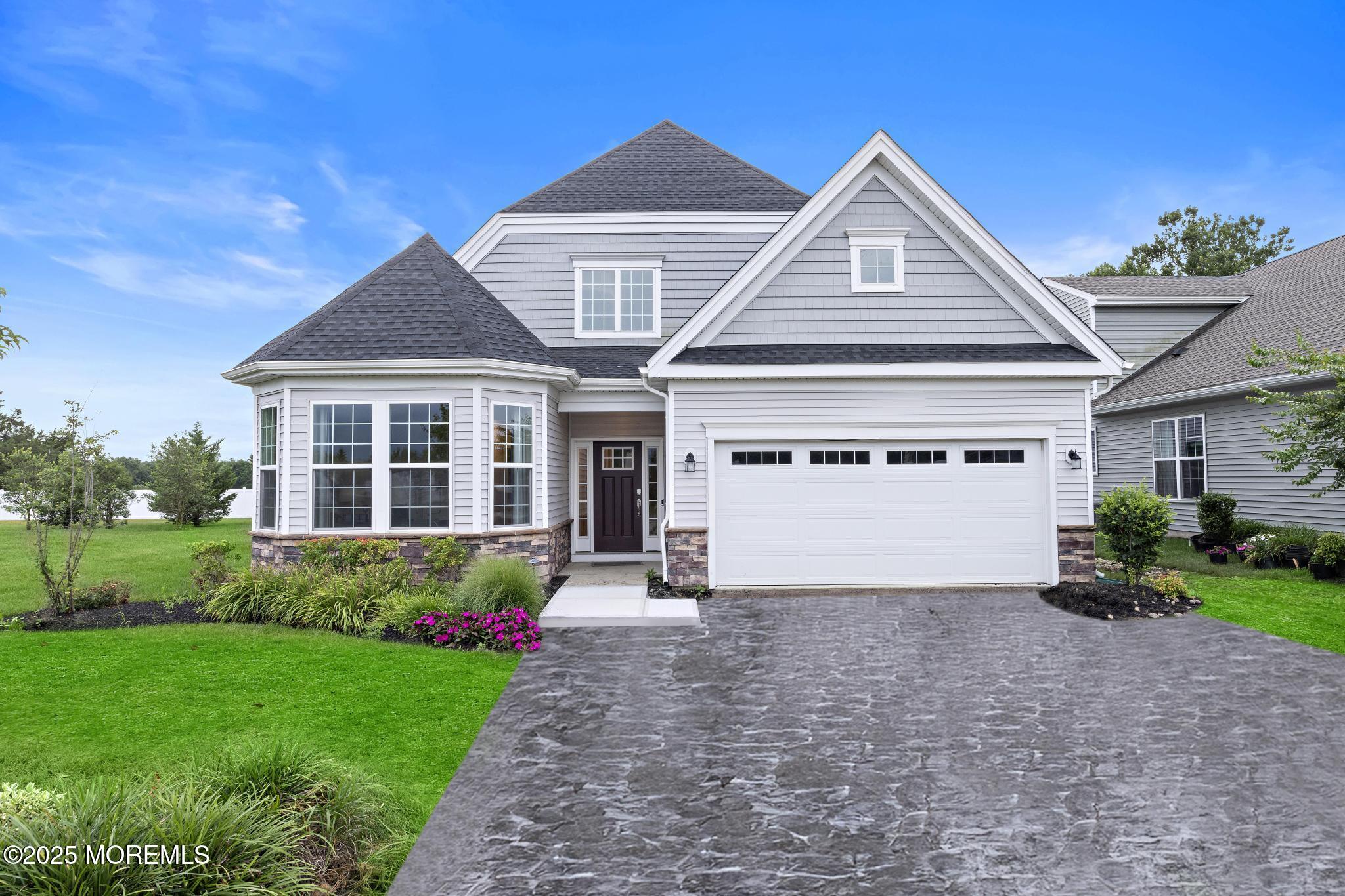 a front view of a house with a garden and yard