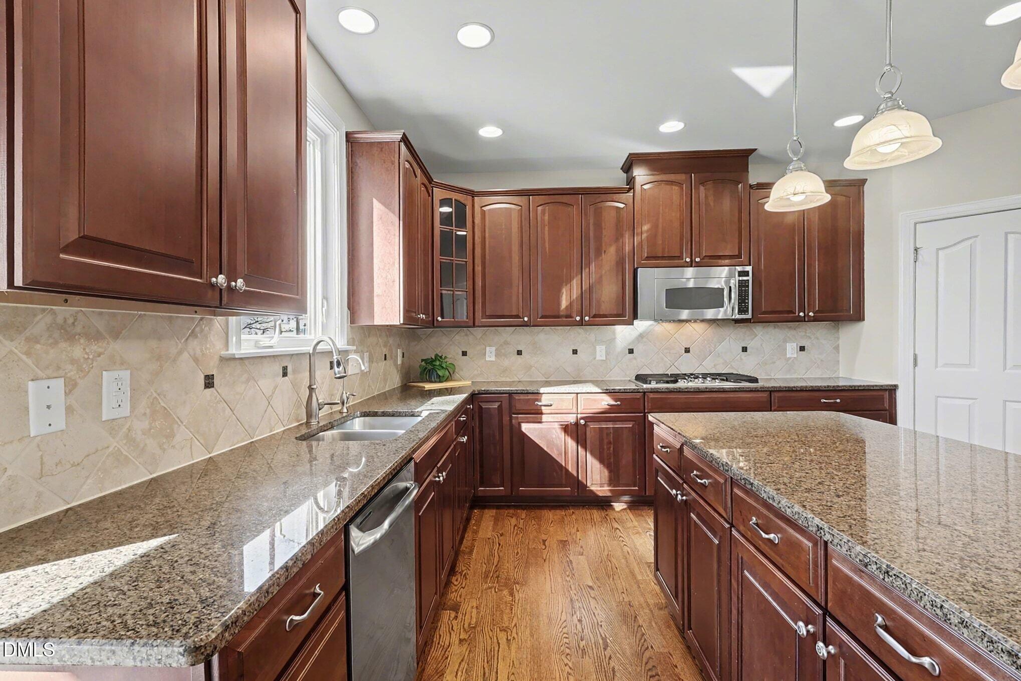 3213 Lebrun Path Fuquay-Varina, NC 27526 - Photo 16 of 58 a kitchen with granite countertop a sink a counter space appliances and cabinets