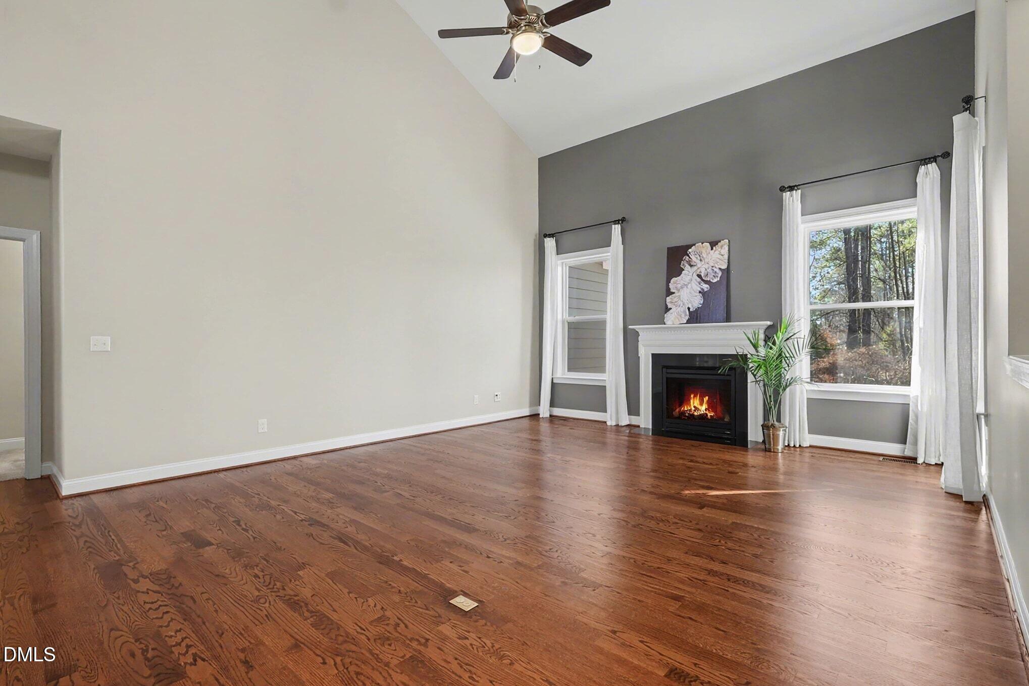 3213 Lebrun Path Fuquay-Varina, NC 27526 - Photo 7 of 58 an empty room with wooden floor fireplace and windows