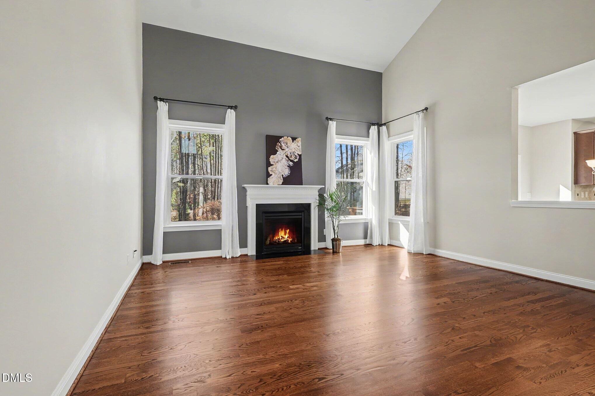 3213 Lebrun Path Fuquay-Varina, NC 27526 - Photo 9 of 58 an empty room with wooden floor fireplace and windows