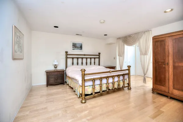 a spacious bedroom with a bed and a window