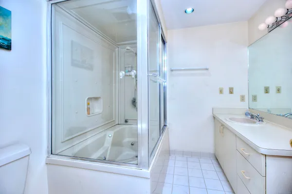 a bathroom with a shower sink and mirror