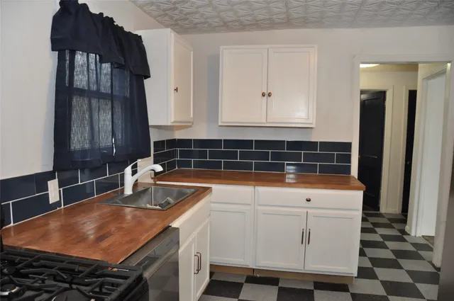 a kitchen with a sink a stove and cabinets