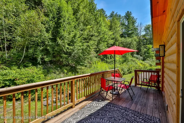 a living room with stainless steel appliances furniture a fireplace and a flat screen tv