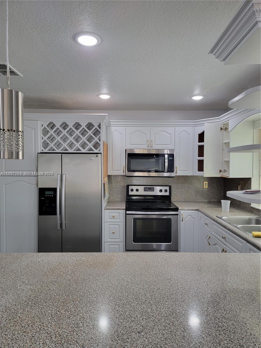 3333 Southwest 156th Court Miami, FL 33185 - Photo 9 of 33 a kitchen with stainless steel appliances granite countertop a refrigerator a stove and a sink with wooden floor