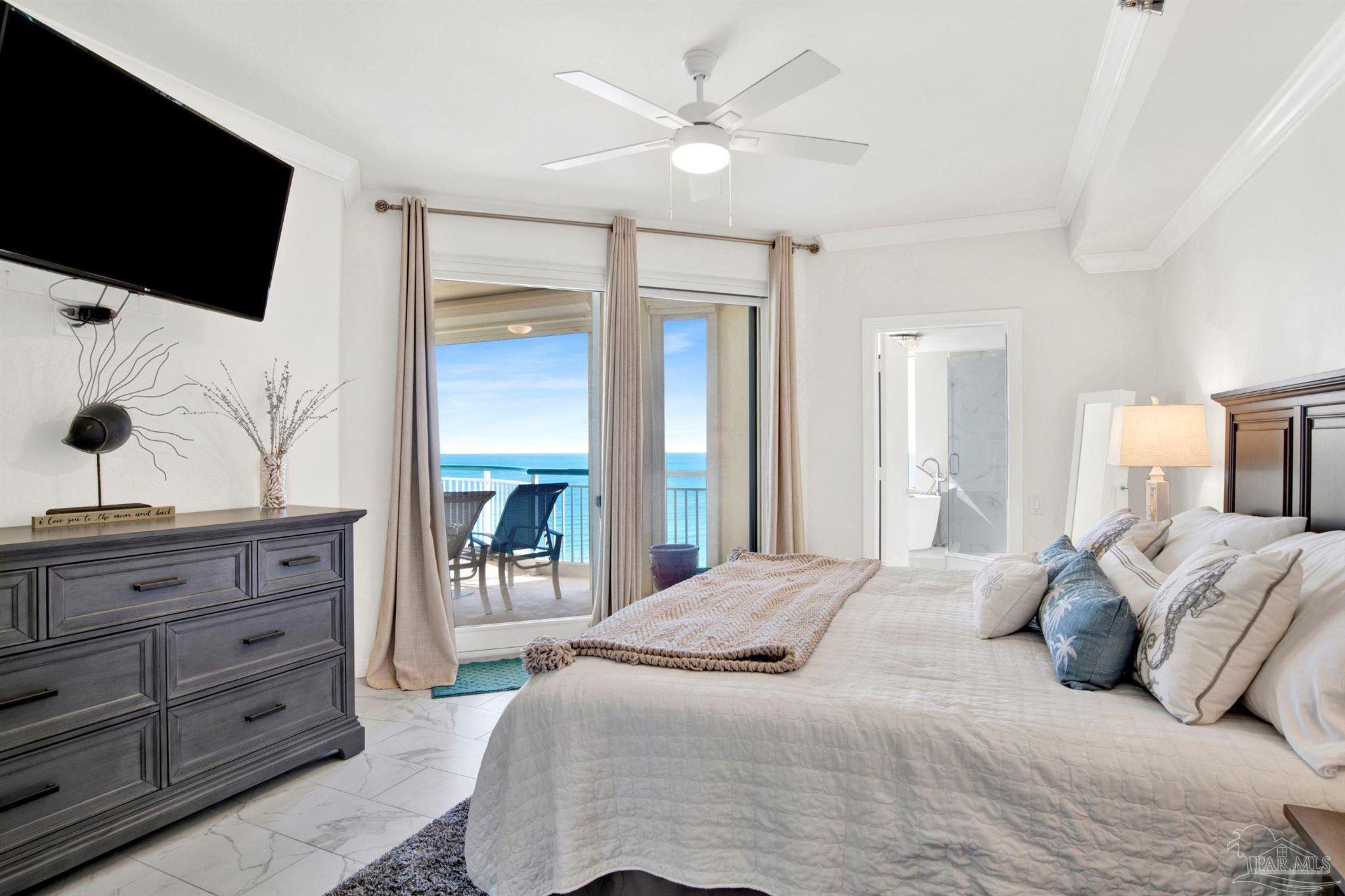 13601 Perdido Key Drive, Unit W10B Pensacola, FL 32507 - Photo 11 of 25 a bedroom with a large bed and a flat tv screen on dresser
