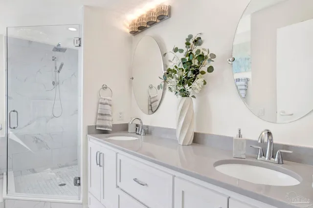 a bathroom with a granite countertop sink a potted plant and a shower