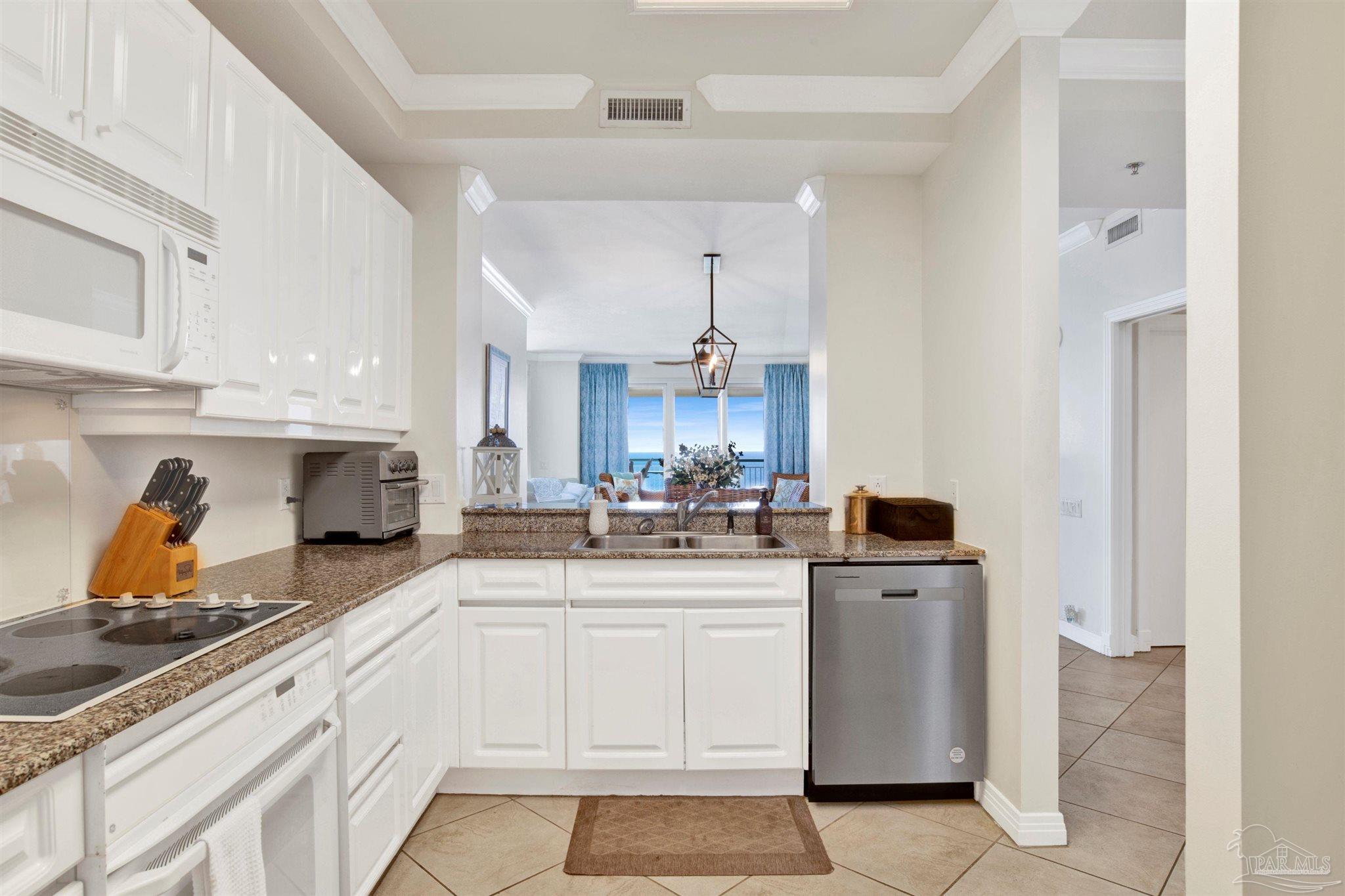 13601 Perdido Key Drive, Unit W10B Pensacola, FL 32507 - Photo 8 of 25 a kitchen with stainless steel appliances a sink stove and cabinets