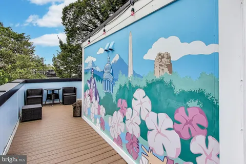 a view of a chairs and table on the roof deck
