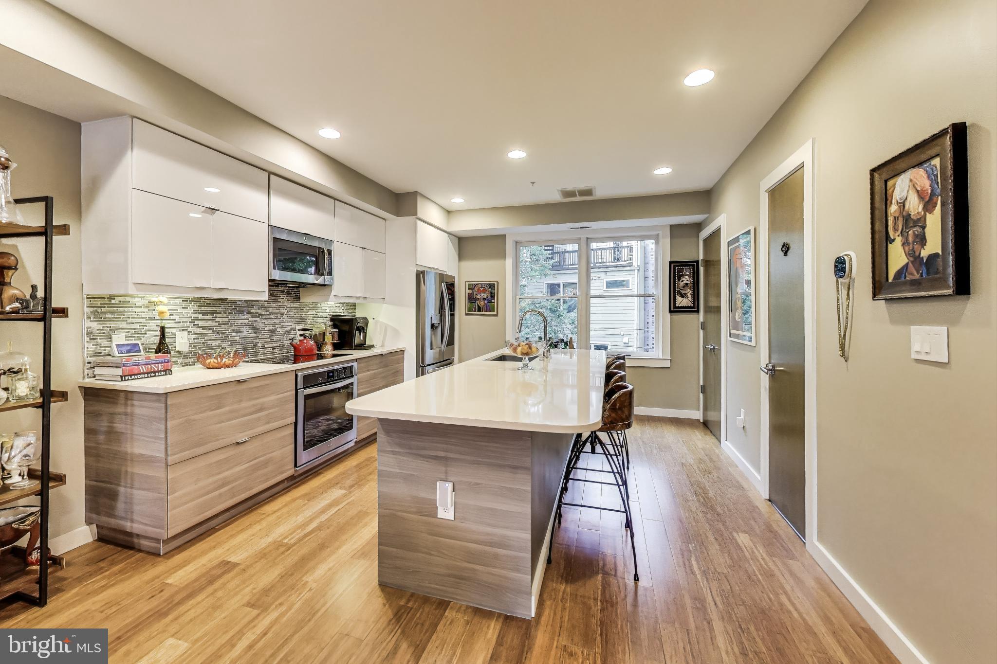 1242 New Jersey Avenue Northwest Washington, DC 20001 - Photo 9 of 60 a kitchen with stainless steel appliances granite countertop a refrigerator a stove top oven a sink dishwasher and white countertops with wooden floor