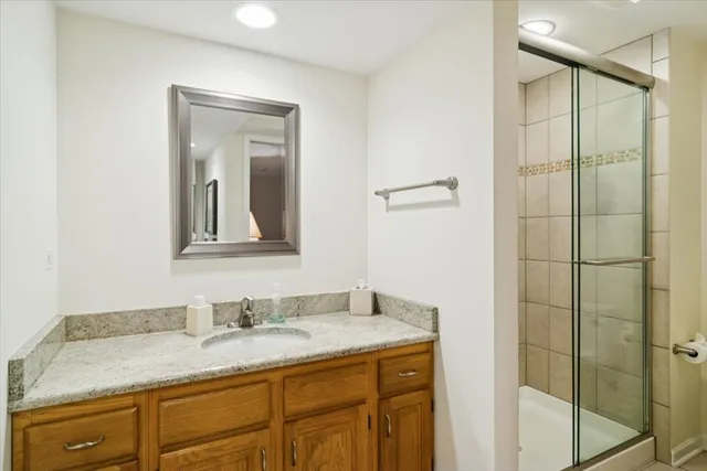 a bathroom with a granite countertop sink and a mirror