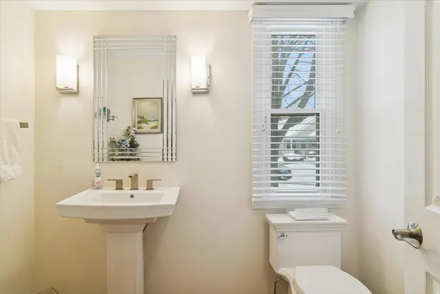 a bathroom with a sink a toilet and a mirror