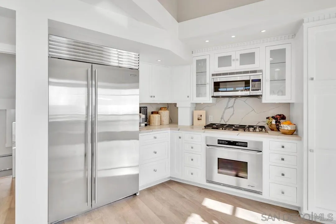 274 Coast Boulevard La Jolla, CA 92037 - Photo 20 of 64 a kitchen with stainless steel appliances white cabinets and a refrigerator
