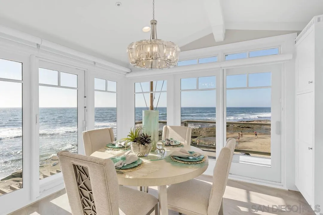 274 Coast Boulevard La Jolla, CA 92037 - Photo 21 of 64 a view of a dining room with furniture large windows and wooden floor