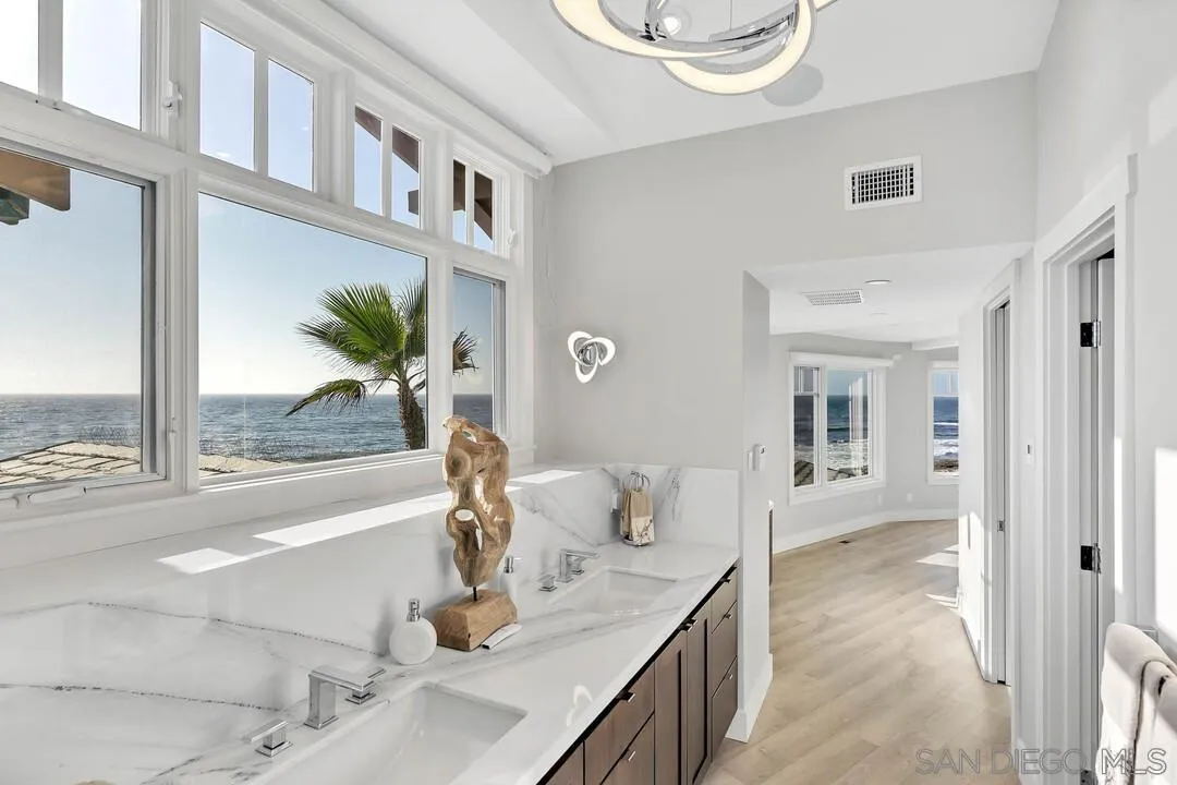 274 Coast Boulevard La Jolla, CA 92037 - Photo 28 of 64 a bathroom with a granite countertop sink a mirror and shower