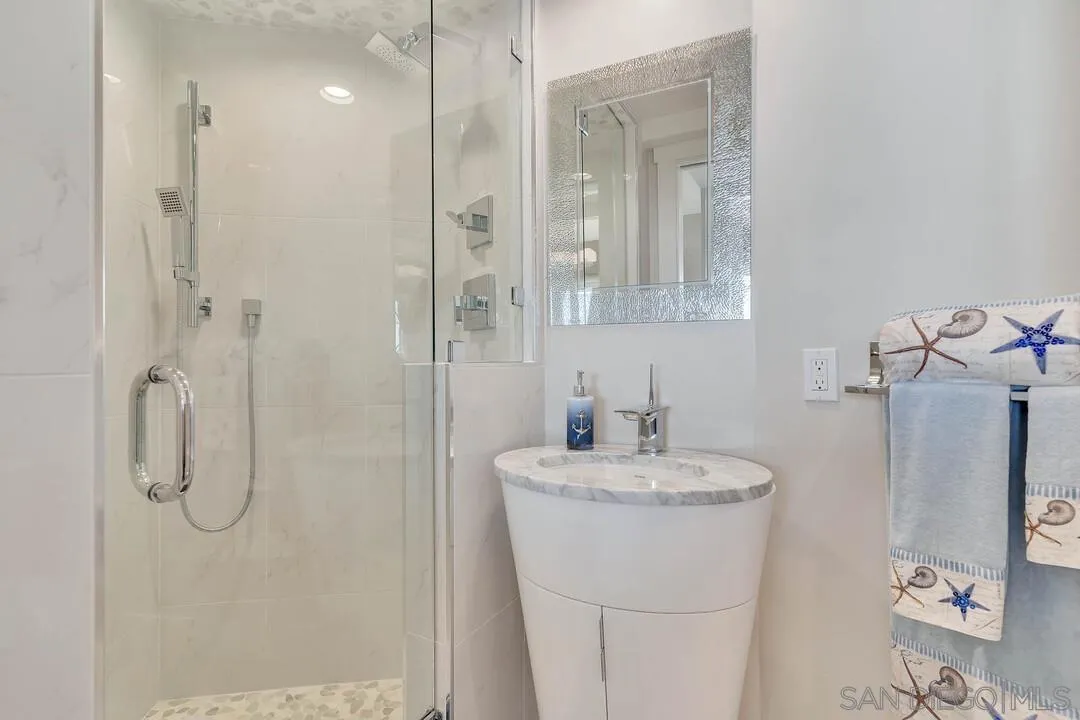 274 Coast Boulevard La Jolla, CA 92037 - Photo 37 of 64 a bathroom with a sink a vanity and shower