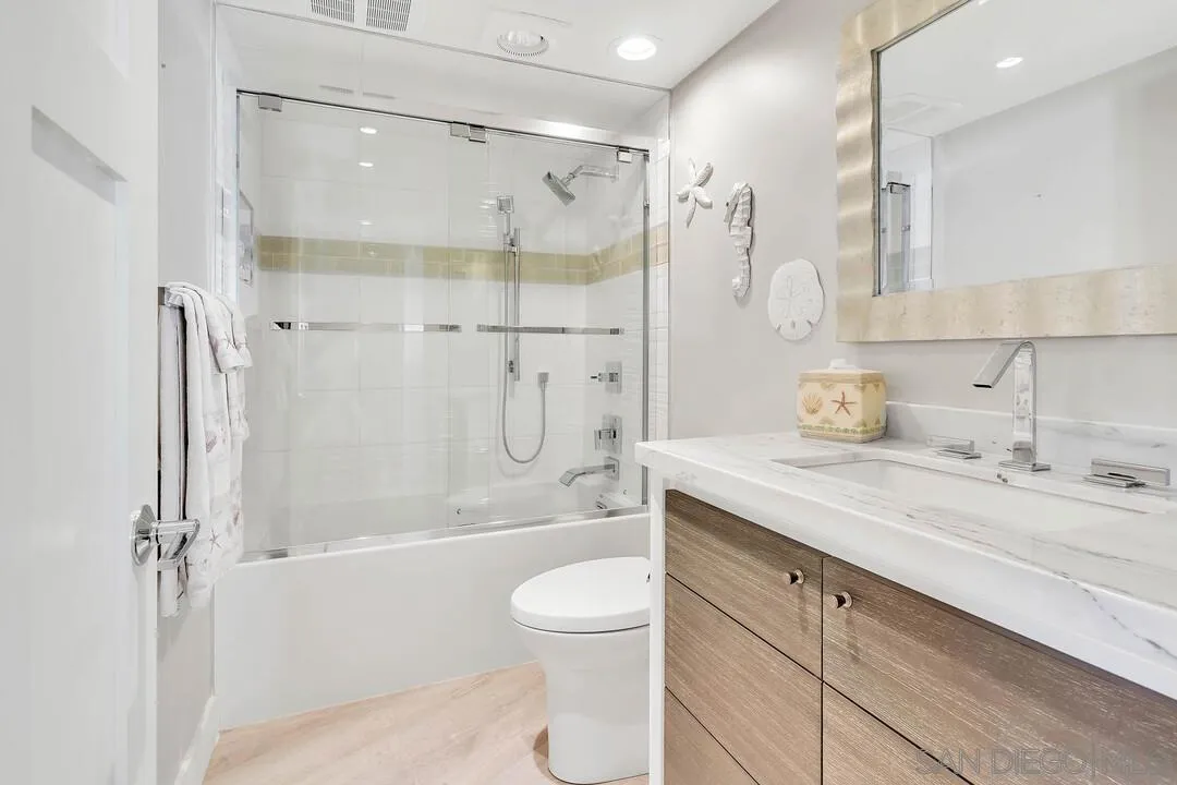 274 Coast Boulevard La Jolla, CA 92037 - Photo 41 of 64 a bathroom with a granite countertop sink a toilet and shower