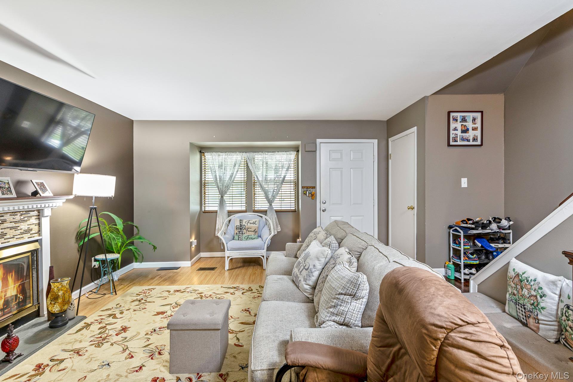 17 Stone Commons Yaphank, NY 11980 - Photo 10 of 31 Living area featuring wood-finish flooring and a fireplace with a decorative mantel and stone-look surround