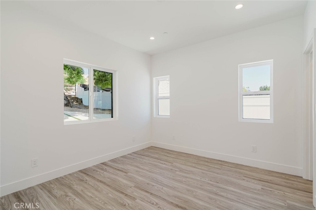 17846 Rinaldi Street Granada Hills, CA 91344 - Photo 19 of 34 a view of an empty room with wooden floor and a window