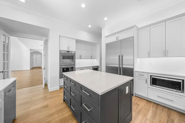 a kitchen with cabinets and wooden floor