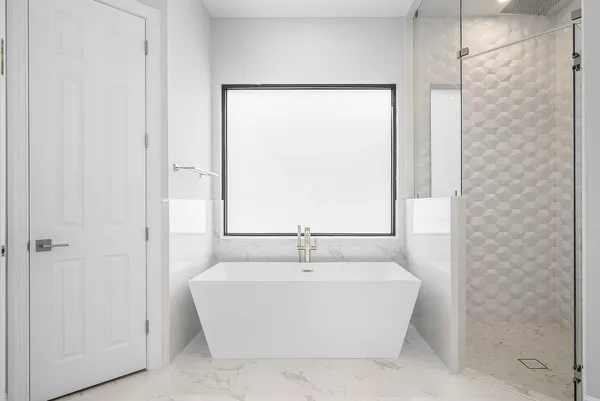 a large bathroom with a large tub sink vanity and granite