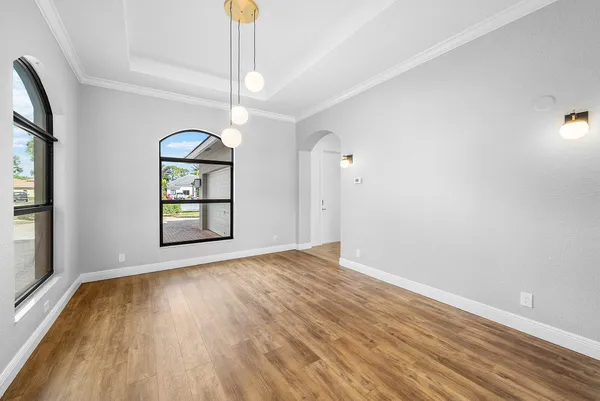 a view of an empty room with wooden floor and staircase