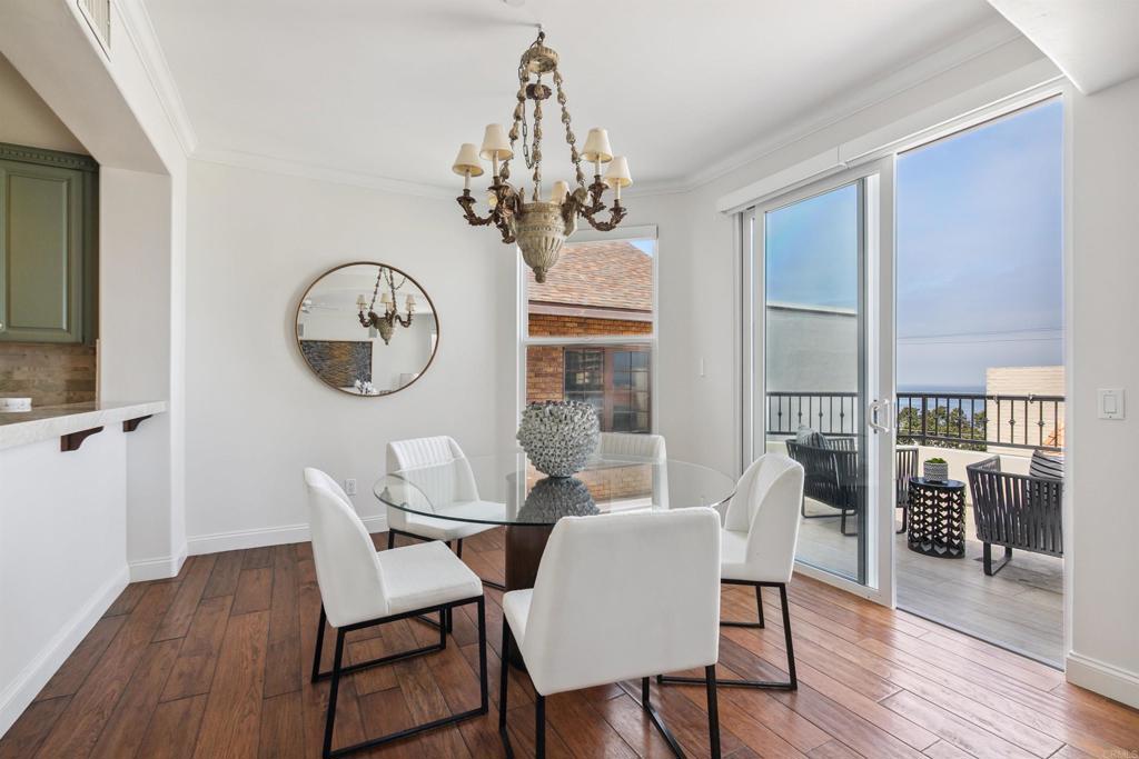 848 Prospect Street, Unit D La Jolla, CA 92037 - Photo 12 of 17 a dining room with wooden floor a chandelier a glass table and chairs