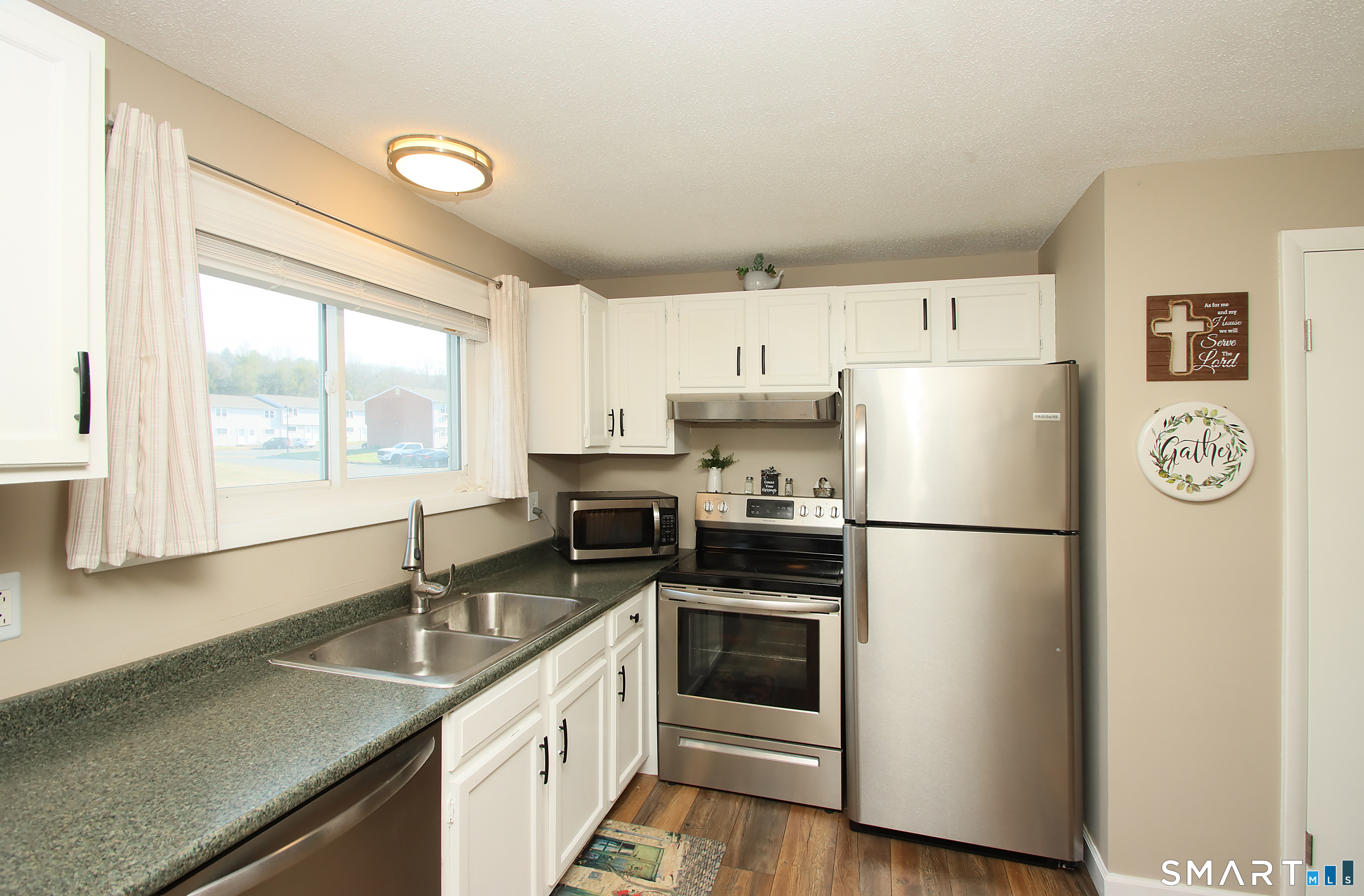 1081 New Haven Road, Unit 10C Naugatuck, CT 06770 - Photo 3 of 16 a kitchen with a refrigerator a stove a sink and a window