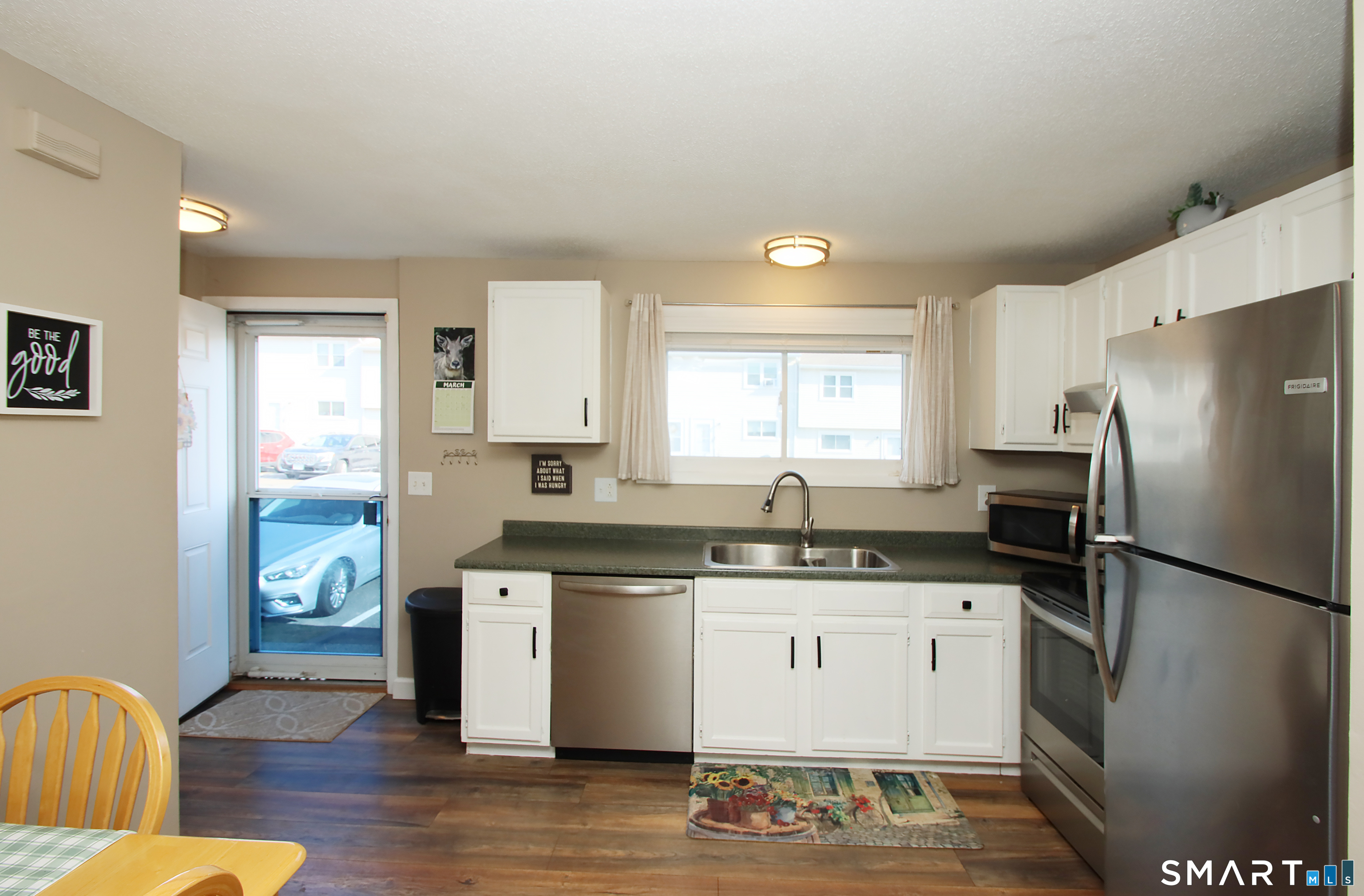 1081 New Haven Road, Unit 10C Naugatuck, CT 06770 - Photo 4 of 16 a kitchen with stainless steel appliances granite countertop a refrigerator a sink dishwasher a stove a dining table and chairs with wooden floor