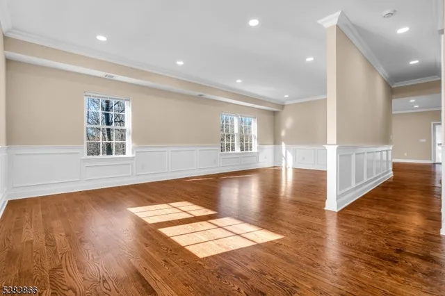 a view of empty room with wooden floor and floor to ceiling window