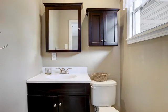 a bathroom with a sink a toilet and mirror