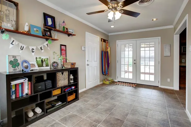 a room with lots of books and a fan