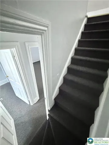 a view of staircase with white walls and a window