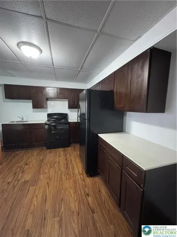 a kitchen with a wooden floor and cabinets