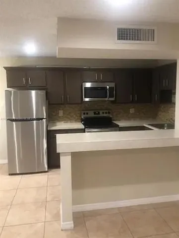 a kitchen with a sink and a refrigerator
