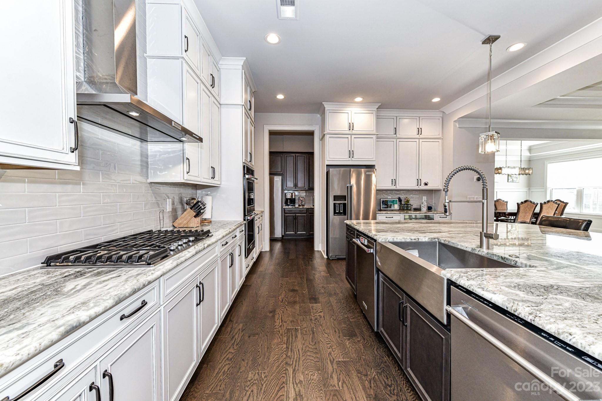 125 Turtleback Ridge, Unit 122 Matthews, NC 28104 - Photo 12 of 40 a large kitchen with stainless steel appliances granite countertop a lot of counter space and wooden floor
