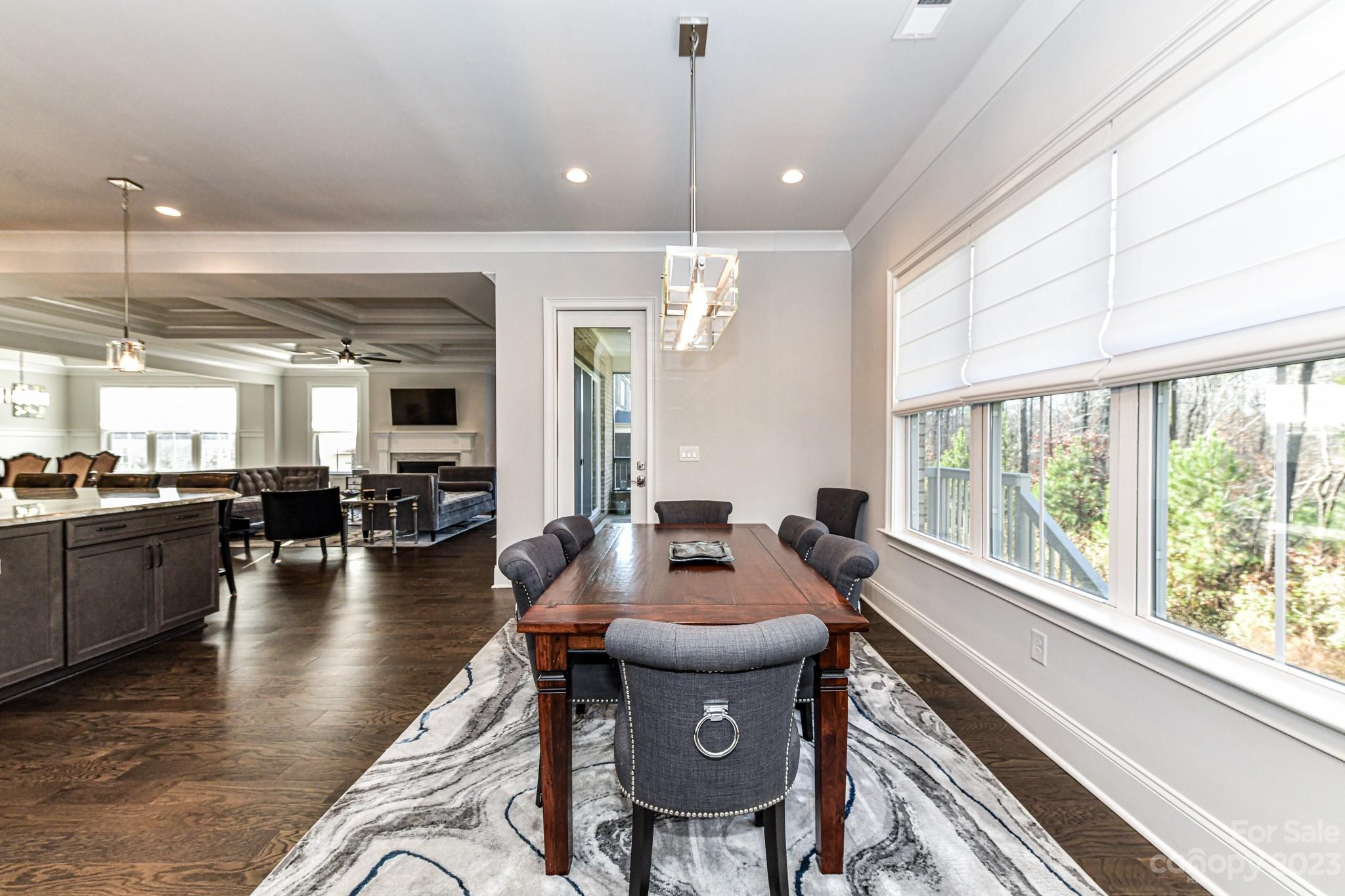 125 Turtleback Ridge, Unit 122 Matthews, NC 28104 - Photo 14 of 40 a dining hall with couches a dining table and chairs with wooden floor
