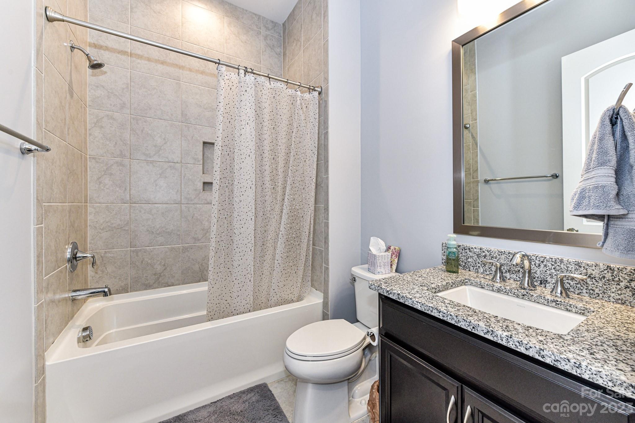 125 Turtleback Ridge, Unit 122 Matthews, NC 28104 - Photo 24 of 40 a bathroom with a granite countertop sink toilet and shower