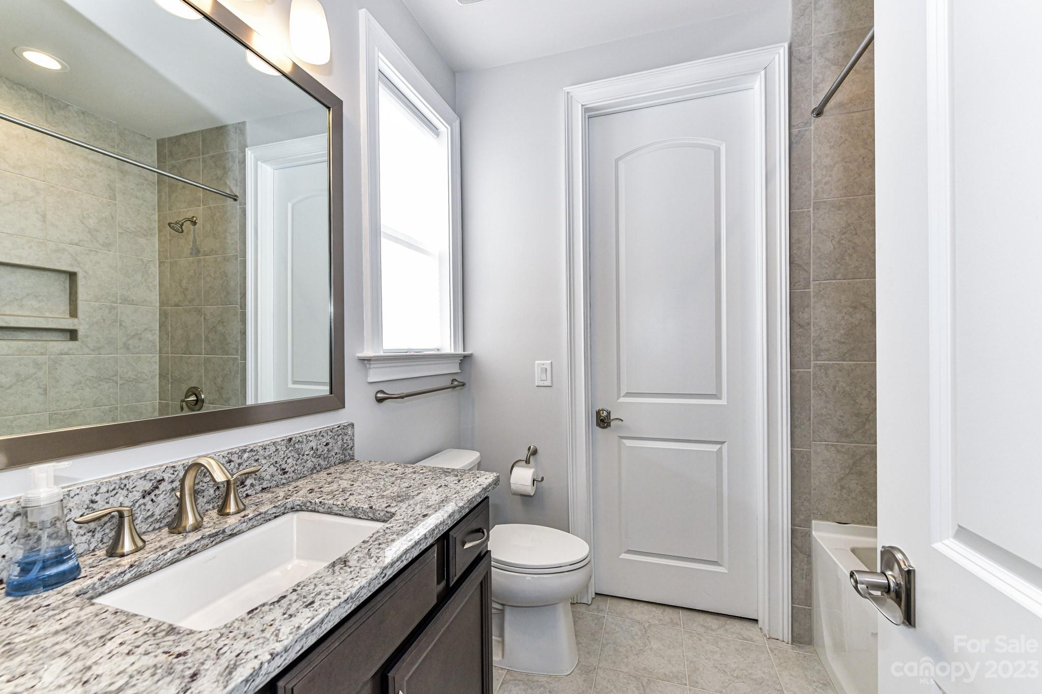 125 Turtleback Ridge, Unit 122 Matthews, NC 28104 - Photo 33 of 40 a bathroom with a granite countertop sink toilet and shower