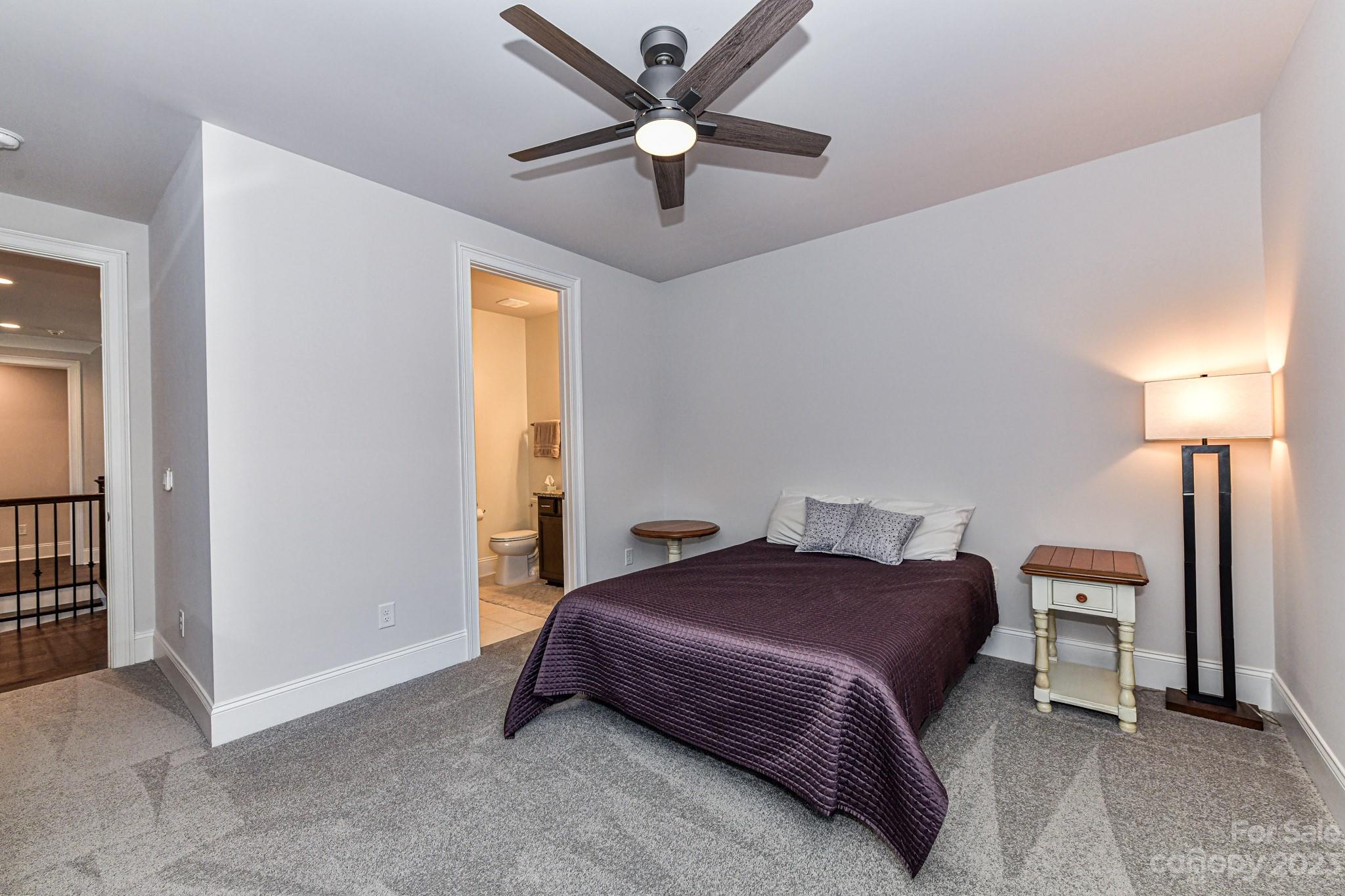 125 Turtleback Ridge, Unit 122 Matthews, NC 28104 - Photo 34 of 40 a bedroom with a bed and a chandelier