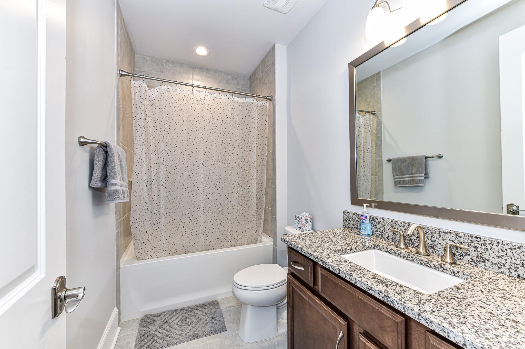125 Turtleback Ridge, Unit 122 Matthews, NC 28104 - Photo 35 of 40 a bathroom with a granite countertop sink toilet and shower