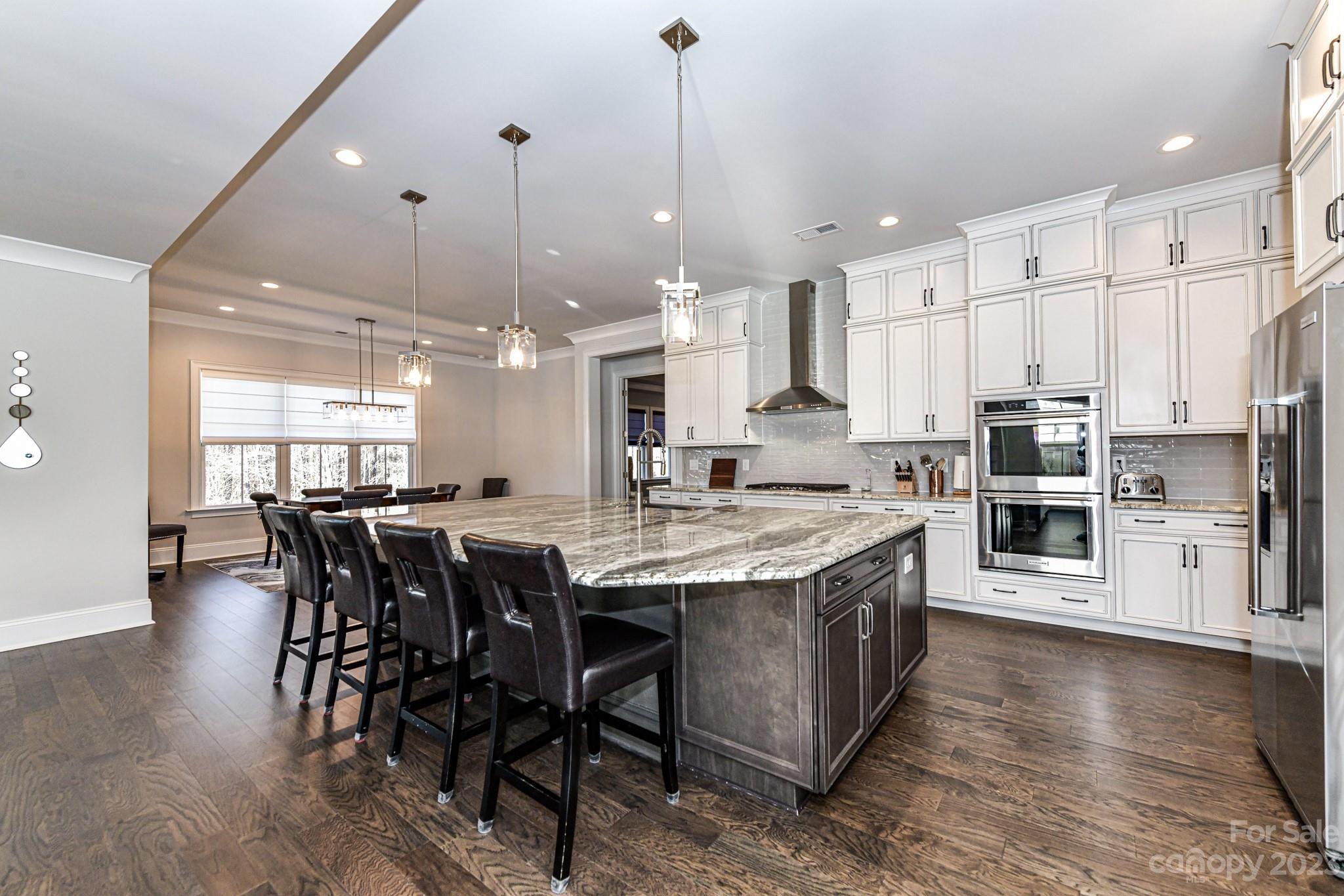 125 Turtleback Ridge, Unit 122 Matthews, NC 28104 - Photo 10 of 40 a kitchen with stainless steel appliances granite countertop a table chairs sink and cabinets