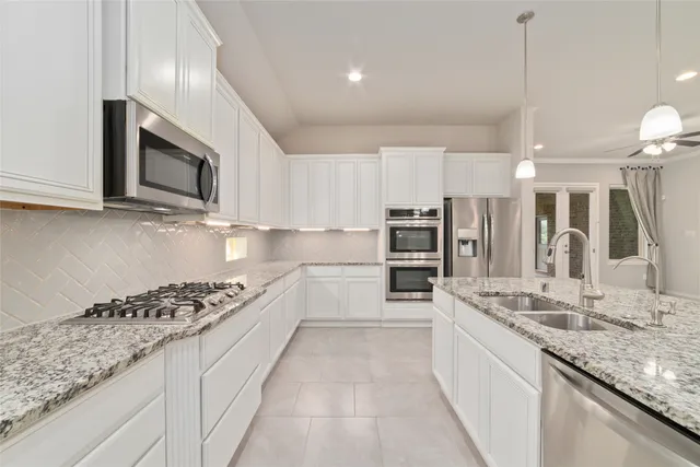 a kitchen with granite countertop white cabinets and white appliances