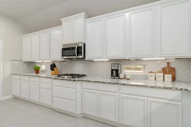 a large kitchen with kitchen island a stove a sink a refrigerator and a fireplace