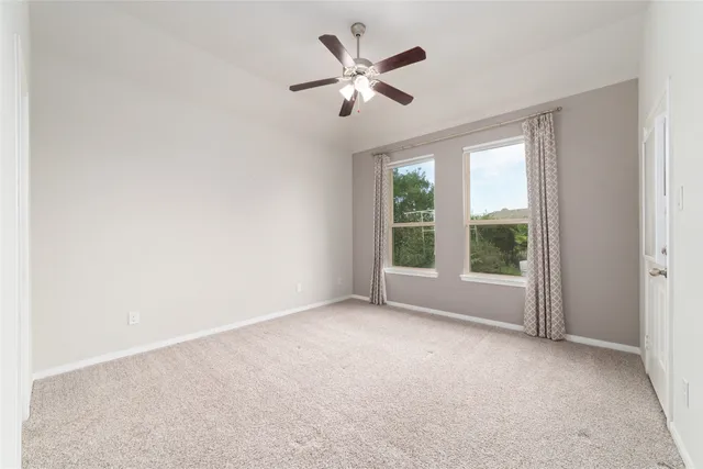 a spacious bedroom with a large bed and a chandelier