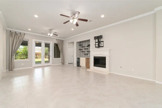 an empty room with a kitchen and a ceiling fan