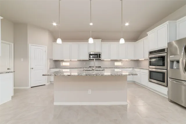 a kitchen with stainless steel appliances kitchen island granite countertop a sink and cabinets