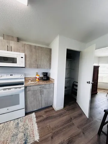 a kitchen with stainless steel appliances granite countertop a refrigerator a sink dishwasher and a stove with wooden floor