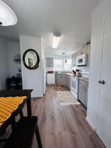 a kitchen with stainless steel appliances granite countertop a stove a sink dishwasher and cabinets with wooden floor